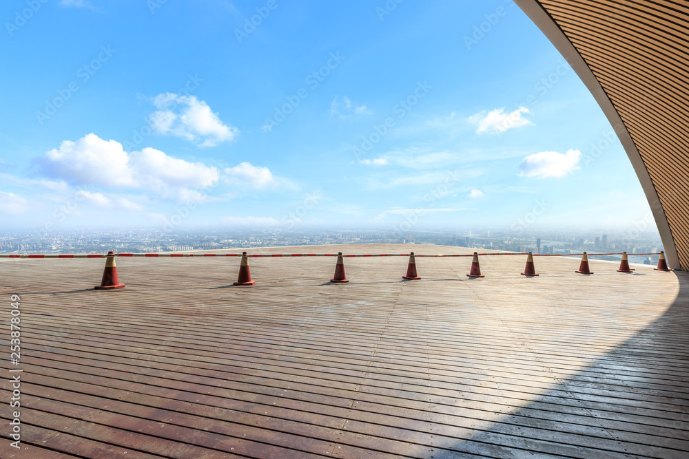 Empty wooden board square and modern city skyline with beautiful clouds