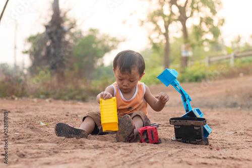 baby playing toy on soil outdoor