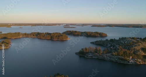 Aerial, drone shot, towards sunset colored islands, in the finnish archipelago, on the Gulf of finland, on a sunny, cold, autumn evening, Varsinais-suomi, Suomi photo