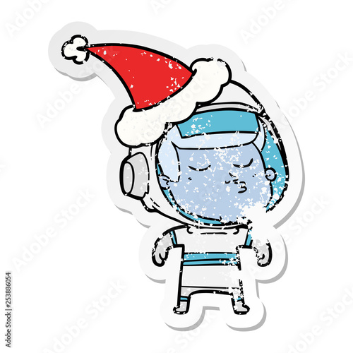 distressed sticker cartoon of a confident astronaut wearing santa hat