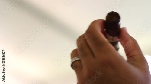 Close up shot of an unsmoked cigar being held by a Caribbean male's hands photo