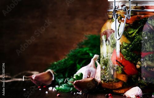 Homemade Canned Grilled Eggplant and Bell Pepper with garlic, parsley, vinegar and oil in glass jar, rustic still life, selective focus