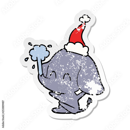 cute distressed sticker cartoon of a elephant spouting water wearing santa hat