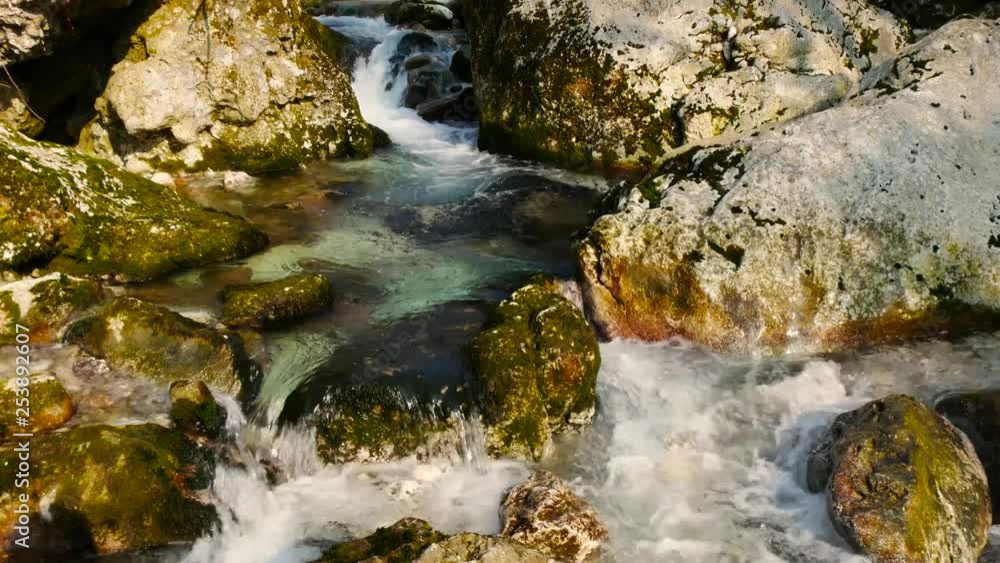 slow water stream flowing through the rocks in winter on a sunny day slow water stream flowing through the rocks in winter on a sunny day