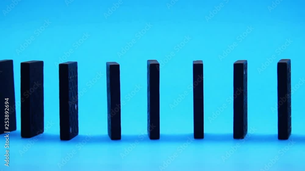 Close Up Of Black Domino Blocks Row On Blue Background. Close Up Of Black Domino Blocks Row On Blue Background.