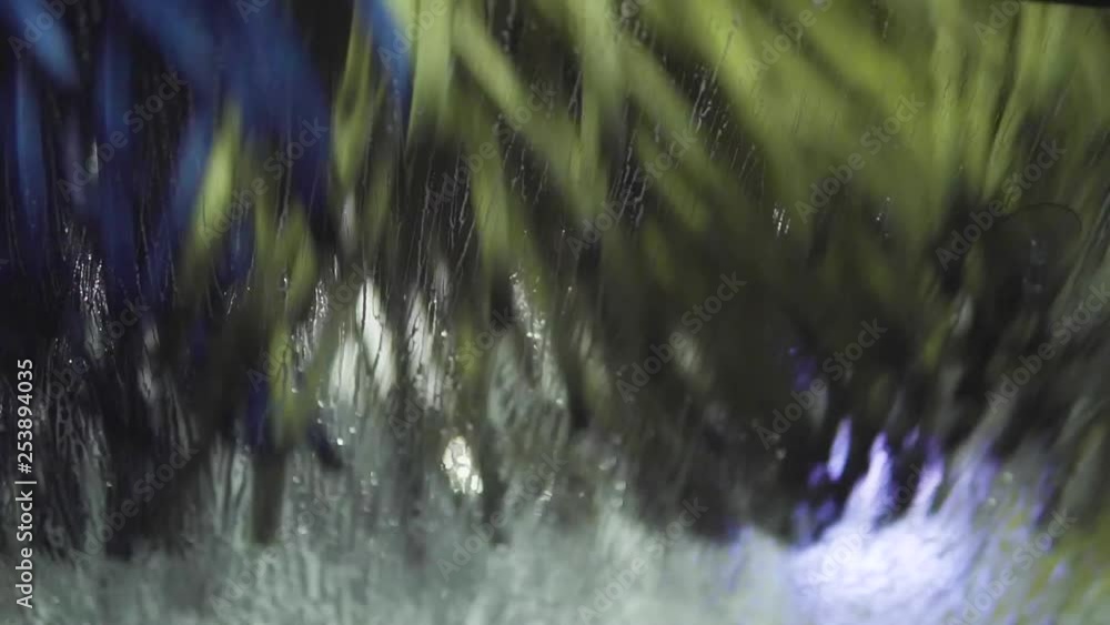 The car wash spinning brush removes soap from the windshield. The car wash spinning brush removes soap from the windshield.