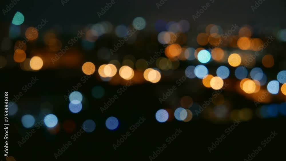 Time lapse of the lights of a city at night, defocused for a bokeh effect.