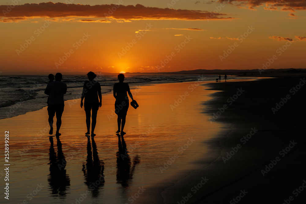 Fototapeta premium Silhouetted family walking on Birubi Beach, Port Stephens, NSW at sunset