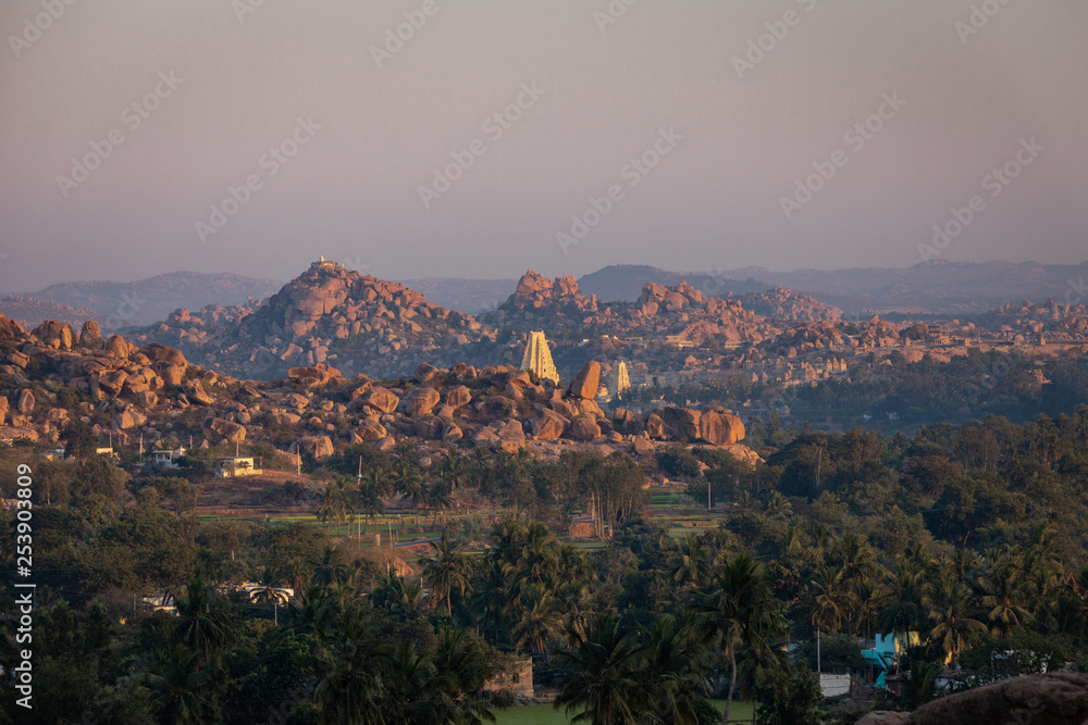 The boulders of Hampi with Virupaksha Temple during sunset in Hampi