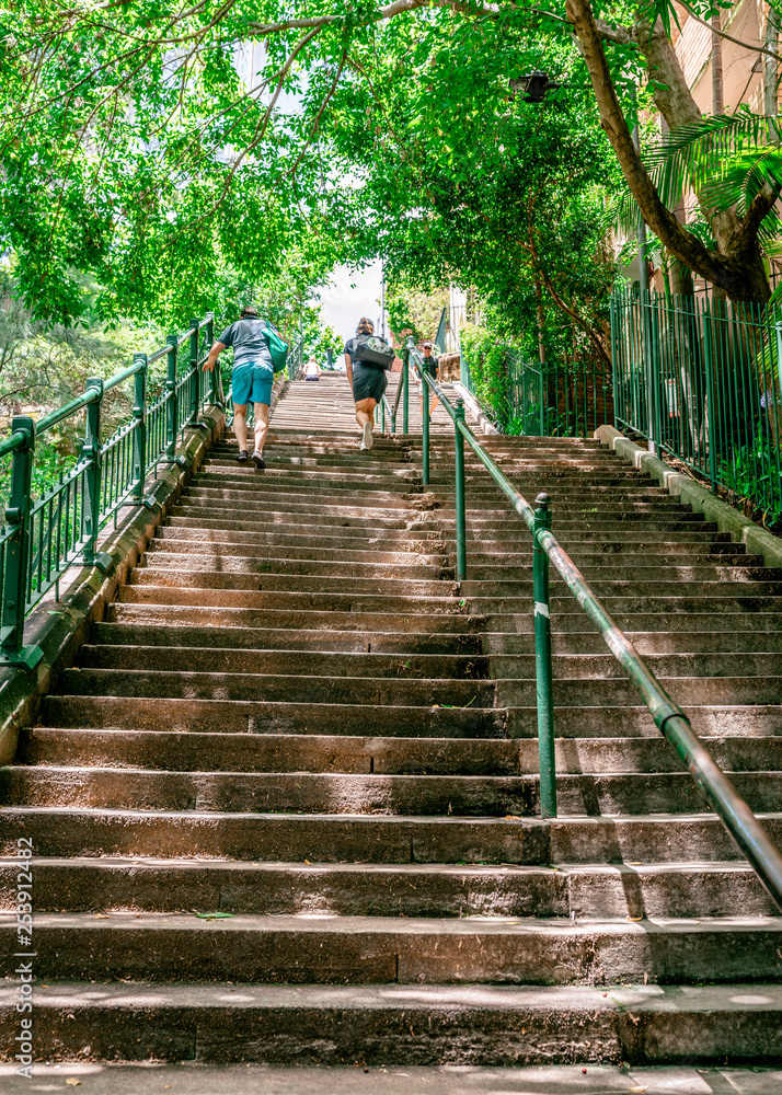Obraz premium Unrecognizable people going up steep old McElhone stairs in Woolloomooloo Sydney NSW Australia