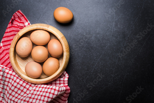 Fresh Eggs (chicken) Close-up with stone white background and wooden.