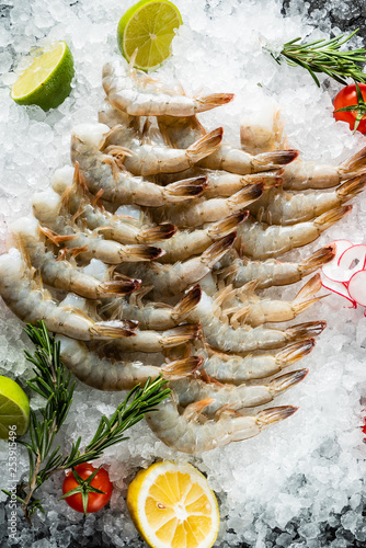 raw shrimps with lime and rosemary on the ice