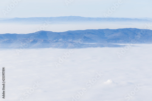Fog filling a valley in Umbria  Italy   with layers of mountains and hills  various shades of blue