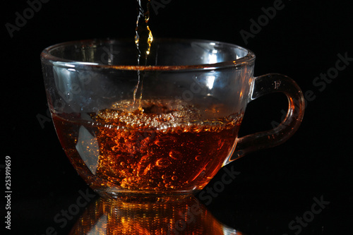 Tea pouring into a glass cup