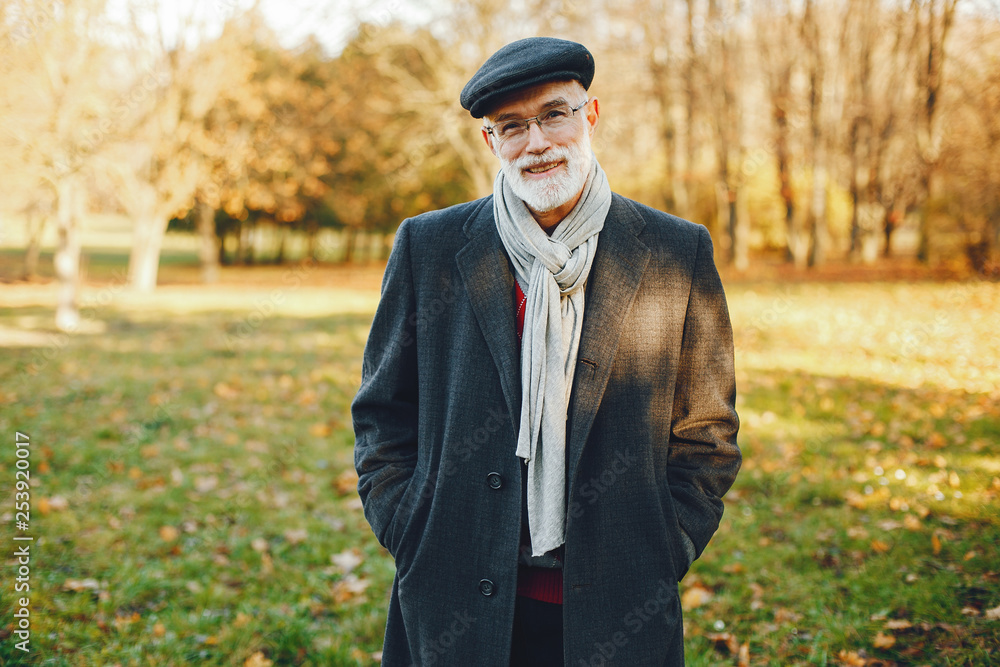 Handsome grandfather in a autumn park. Old man in a gray jacket and hat. Handsome grandfather in a autumn park. Old man in a gray jacket and hat.