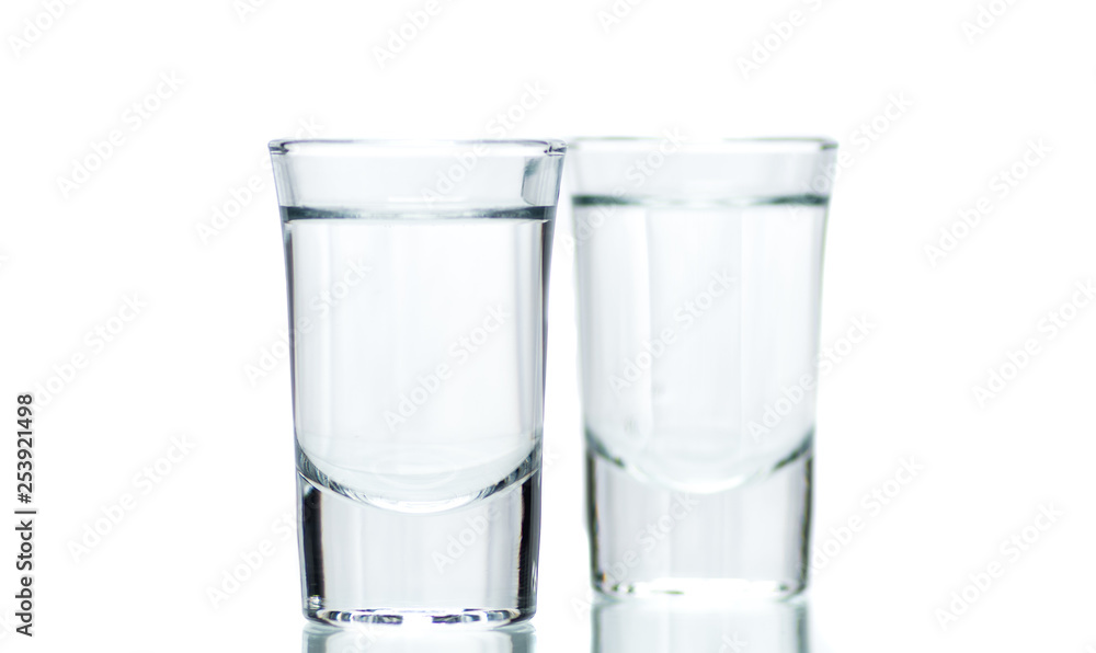 two glasses, shot glasses with liquid on a white background two glasses, shot glasses with liquid on a white background