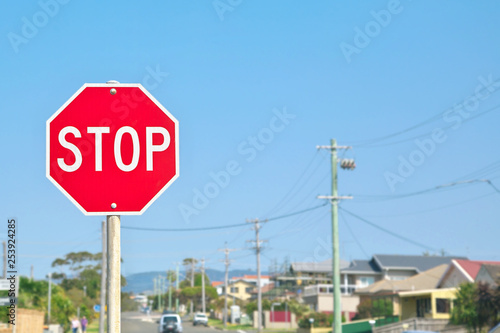 Stop sign with street and blue sky background