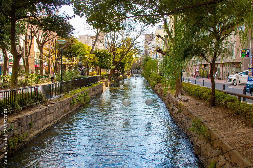 Canal with trees and white lights during daytime in Okayama Japan