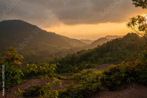 Magnificent yellow sunset with mountains covered by tropical forest landscape © Alexander Zvarich 