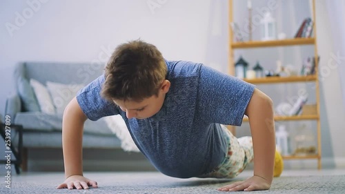 Fat boy doing exercises in the hall