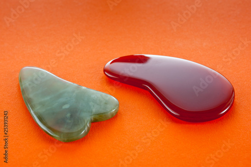 Guasha scrapers for body massage according to the ancient method shot on a bright red background photo