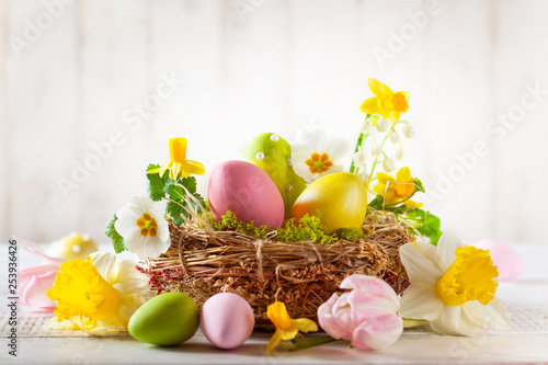 Easter composition with Easter eggs in nest, spring flowers and branches of pussy willows.