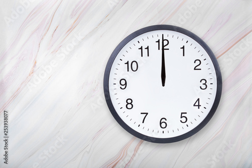 Fotografija Wall clock on marble texture show twelve o'clock