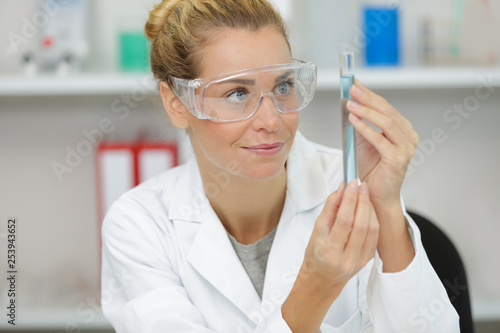 smiling young female doctor holding a flask © auremar