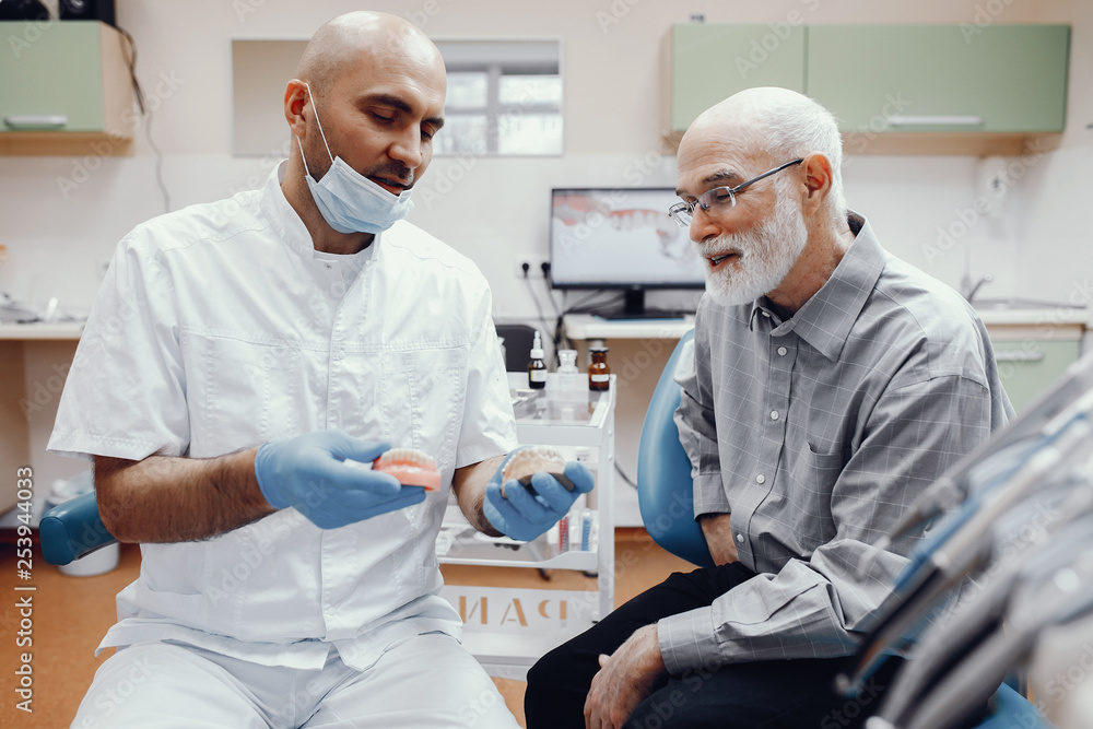 Handsome old man talking to the dendist. Two men in the dentist's office Handsome old man talking to the dendist. Two men in the dentist's office