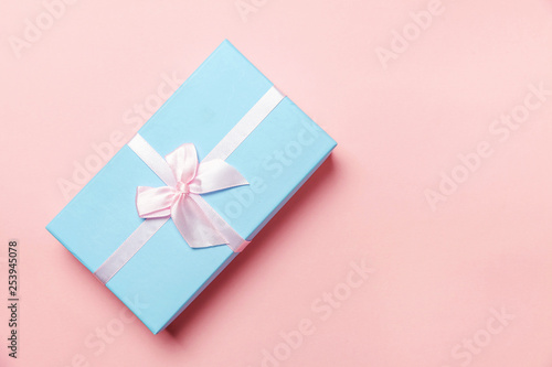 Christmas New Year birthday valentine celebration present romantic concept. Small gift box wrapped blue paper isolated on pink pastel colorful trendy background. Flat lay top view copy space