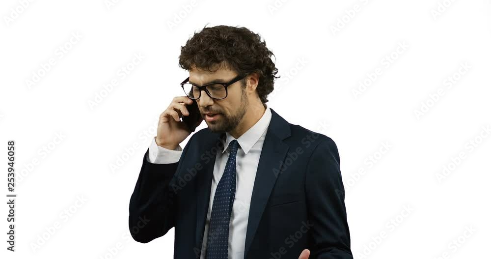 Angry Caucasian nervous businessman in suit and tie speaking on the phone and being not in the mood, then shouting. White background wall. Angry Caucasian nervous businessman in suit and tie speaking on the phone and being not in the mood, then shouting. White background wall.