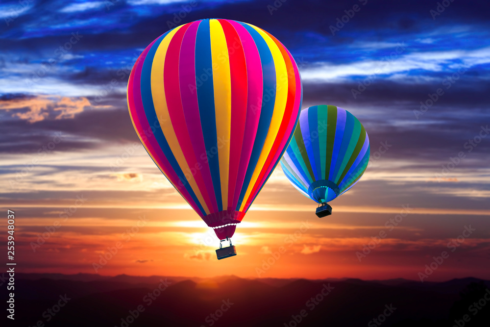 Two hot air balloon soar into the sky at sunrise