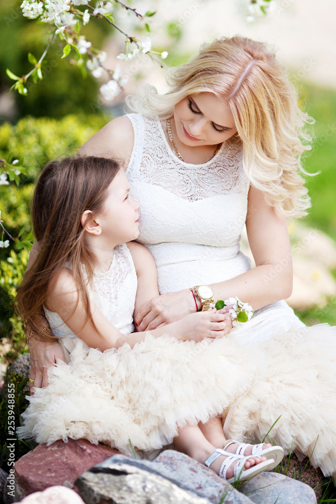 Pregnant mother and her small daughter have fun outdoor. Family look portrait Pregnant mother and her small daughter have fun outdoor. Family look portrait