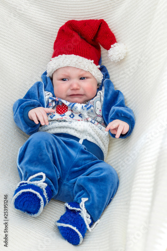 Crybaby in red Christmas cap is naughty and crying photo