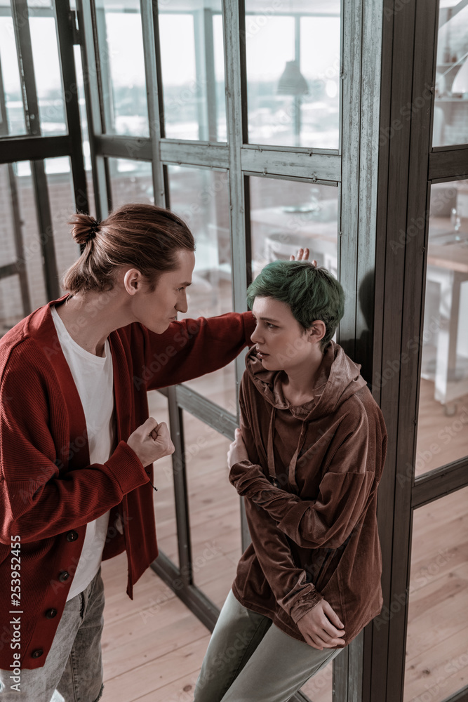 Fototapeta premium Young woman with short hair cut looking at nervous angry husband