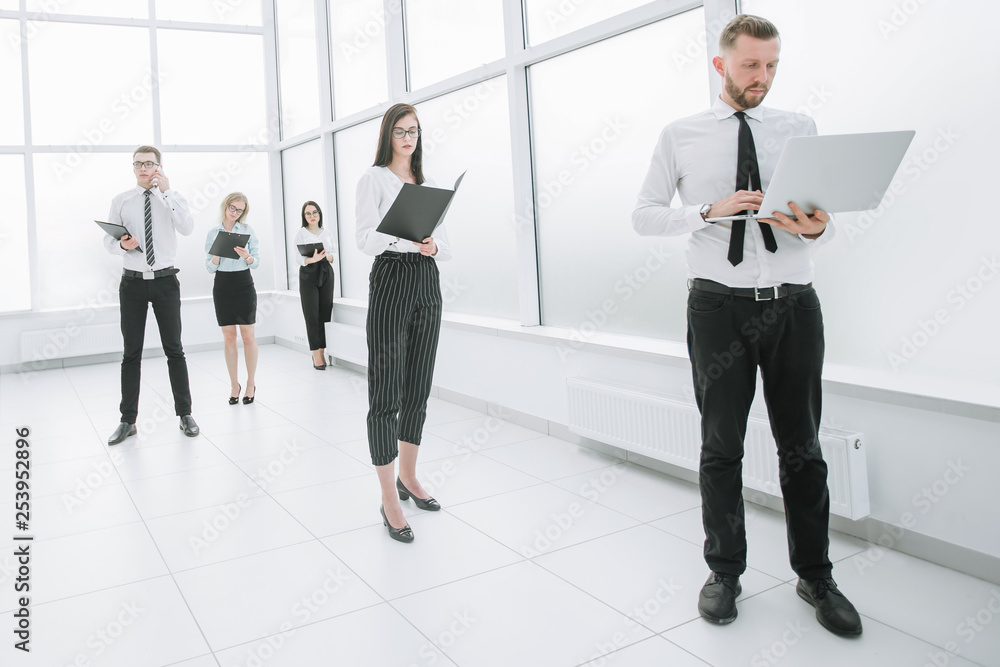 Executive employees of the company standing in the office lobby Executive employees of the company standing in the office lobby