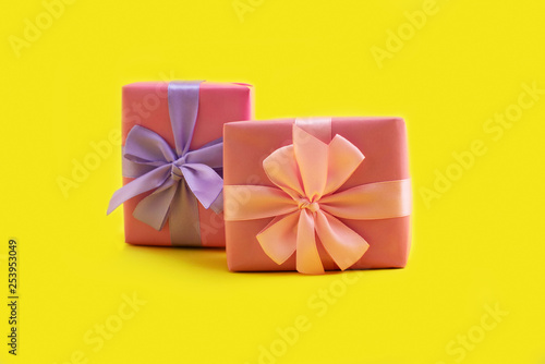 Fototapeta Naklejka Na Ścianę i Meble -  Gift box bow pink on yellow background Festive decoration design