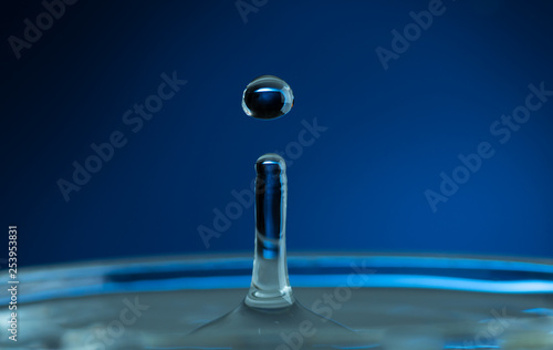 splash from a falling drop of water in a glass on a dark background