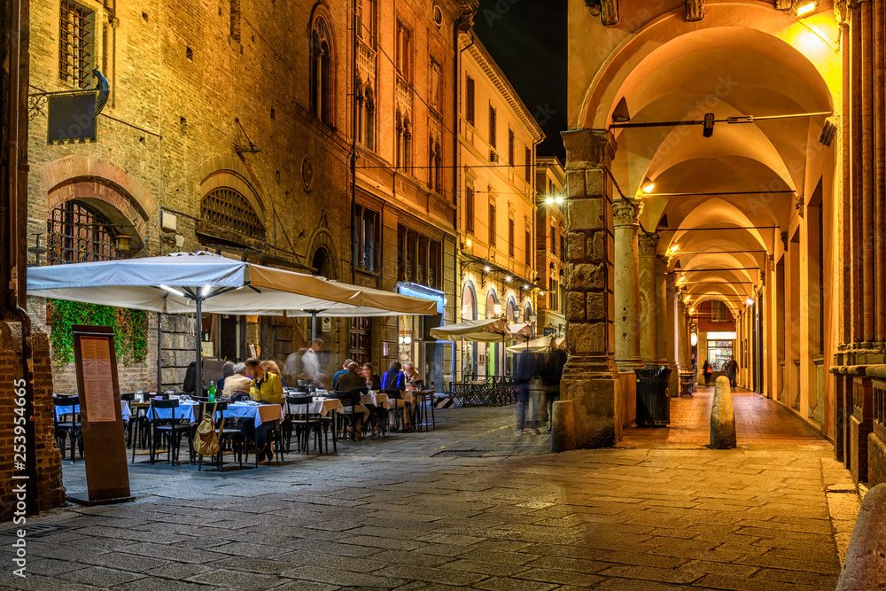 Fotografie, Obraz Old narrow street with arcade in Bologna, Emilia Romagna, Italy