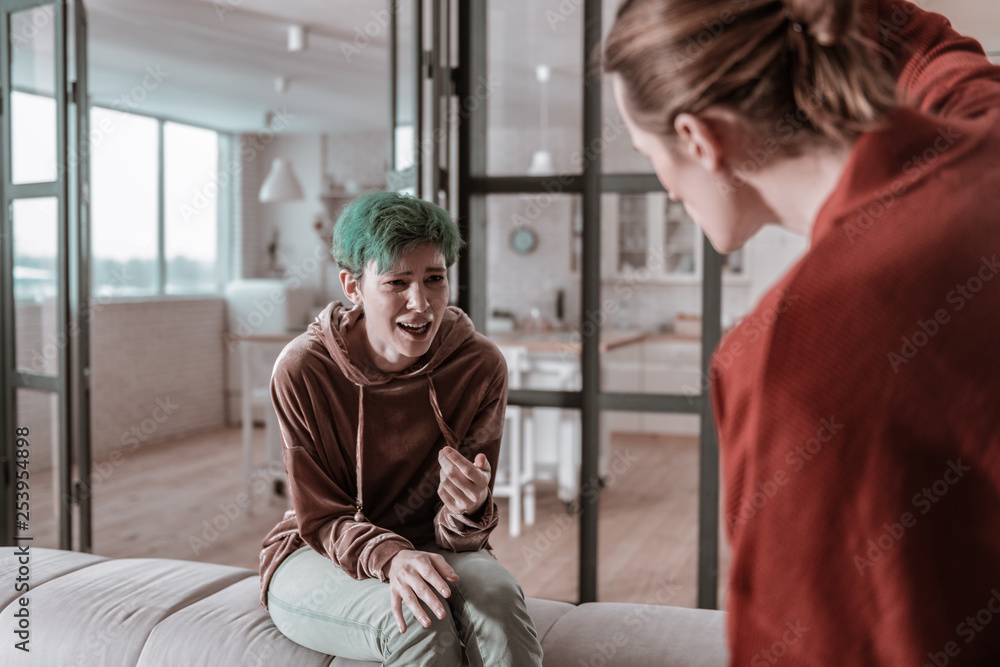 Obraz premium Green-haired woman crying while having argument with husband