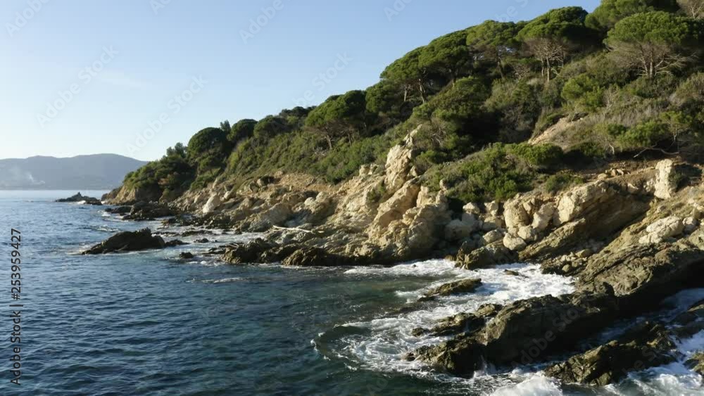Aerial low flight along rocky coastline with waves and ripples, mediterranean landscape Aerial low flight along rocky coastline with waves and ripples, mediterranean landscape