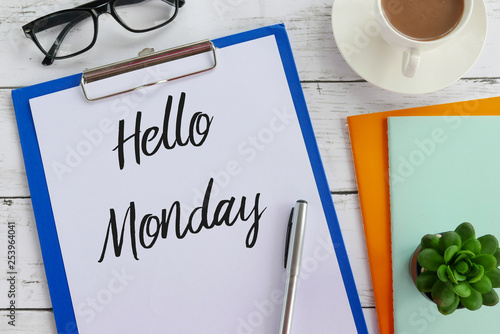 Foto Top view of glasses,coffee,plant,notebook,pen,clipboard and paper written with Hello Monday