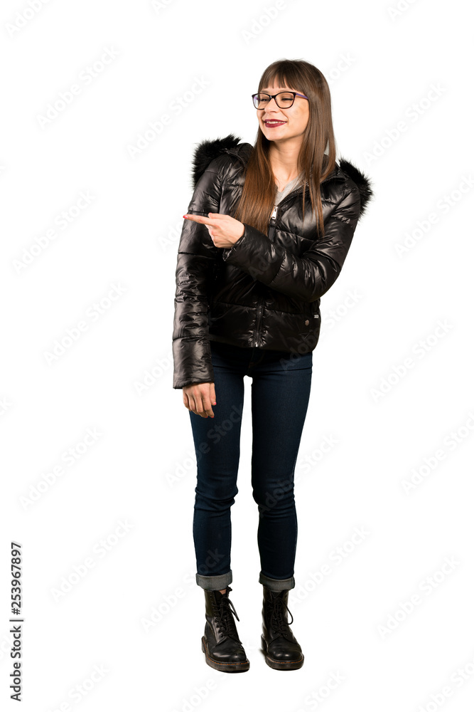 Full-length shot of Woman with glasses pointing to the side to present a product Full-length shot of Woman with glasses pointing to the side to present a product