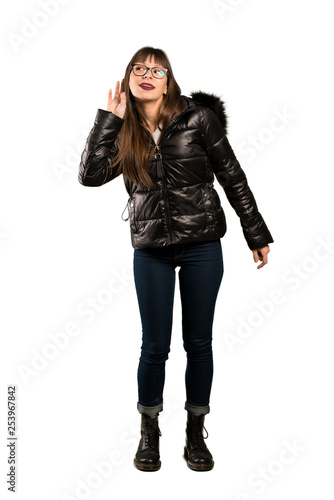 Full-length shot of Woman with glasses listening to something by putting hand on the ear