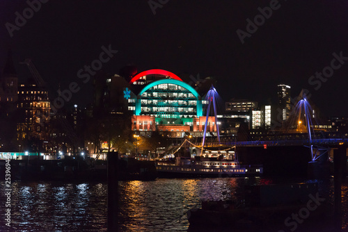 Illuminated Charing Cross railway station building in Christmas colours and Hungerford bridge at night  London  England  UK