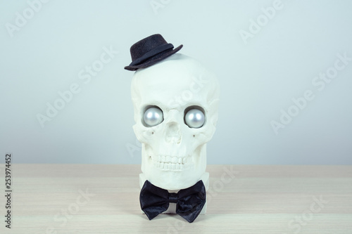 skull sculpture with black hat and a black bow tie. holiday background concept. Free space for design.