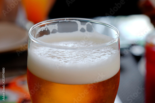 a glass of cold beer with foam close-up