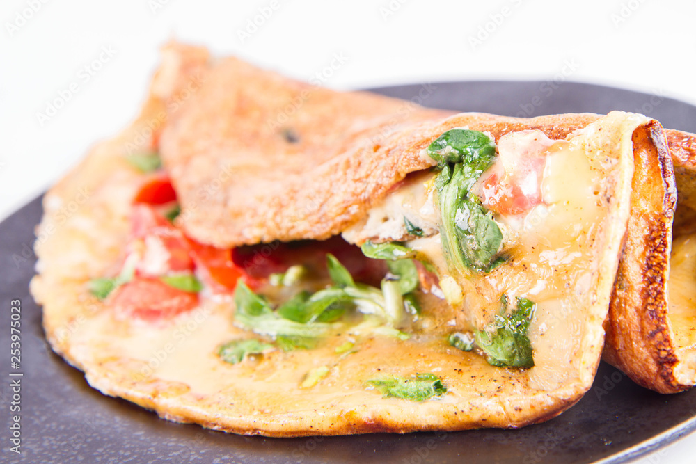 Omelette with tomatoes and fresh corn salad on a white background Omelette with tomatoes and fresh corn salad on a white background