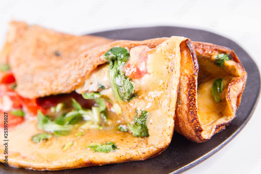 Omelette with tomatoes and fresh corn salad on a white background