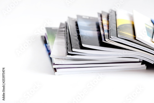Pile of advertising magazines on a white background.